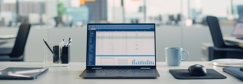 FacilityService En öppen laptop på ett skrivbord i kontorsmiljö med diagram och tabeller på skärmen.